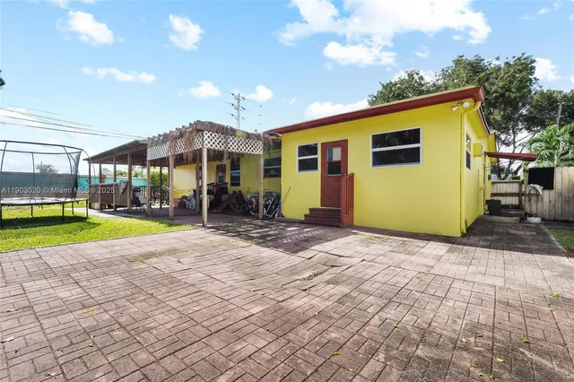 a view of a house with backyard and sitting area