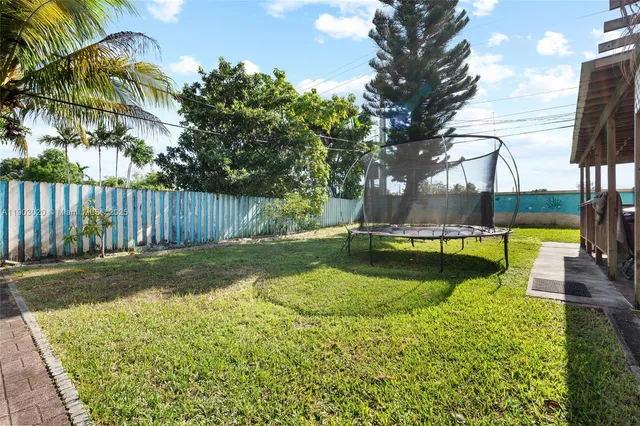 a view of a swimming pool with a patio and a yard