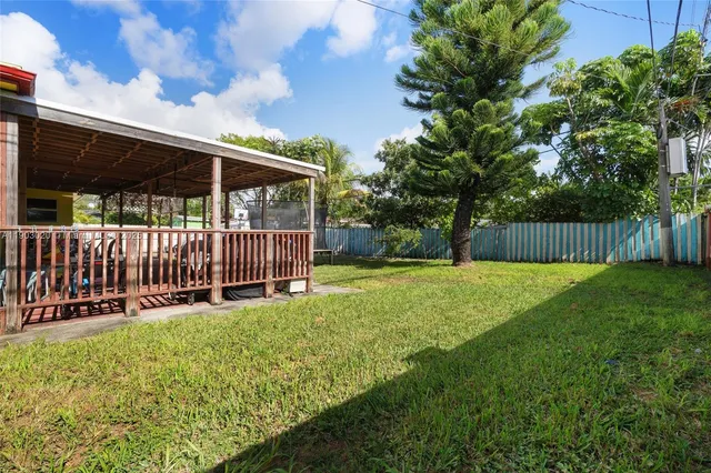 a view of a backyard with a small cabin and wooden fence