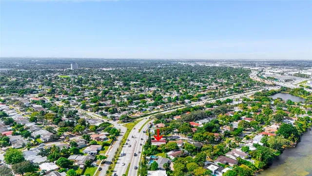 an aerial view of residential houses with outdoor space and trees