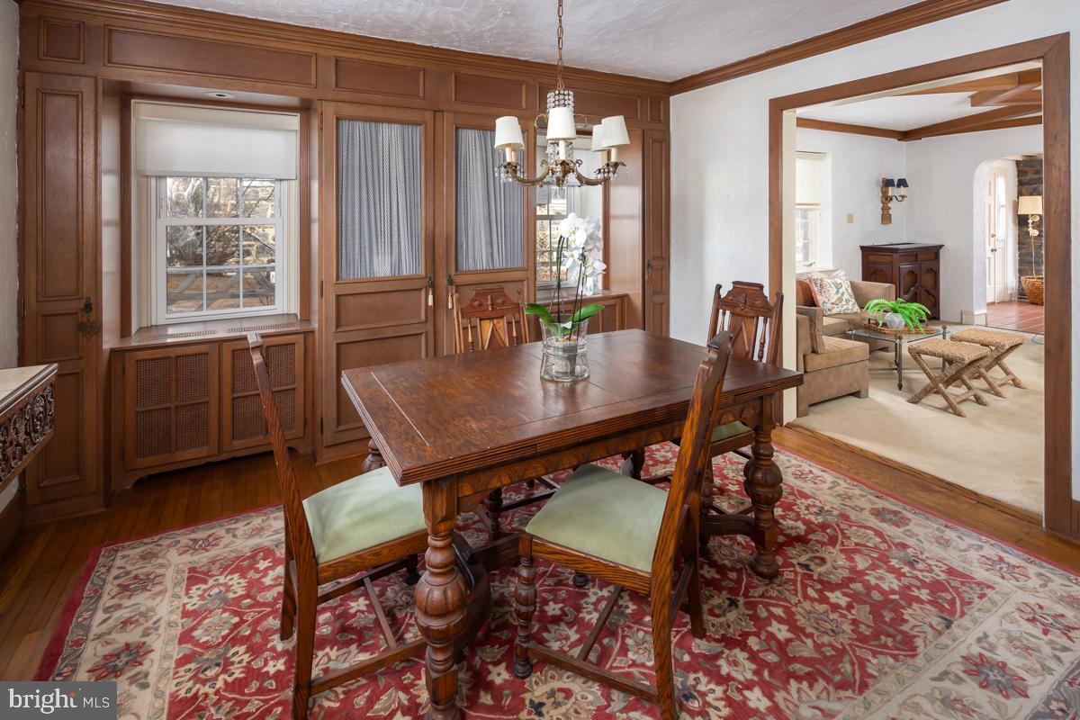 120 Crosshill Road Wynnewood, PA 19096 - Photo 7 of 29 a dining room with wooden floor a chandelier a wooden table and chairs