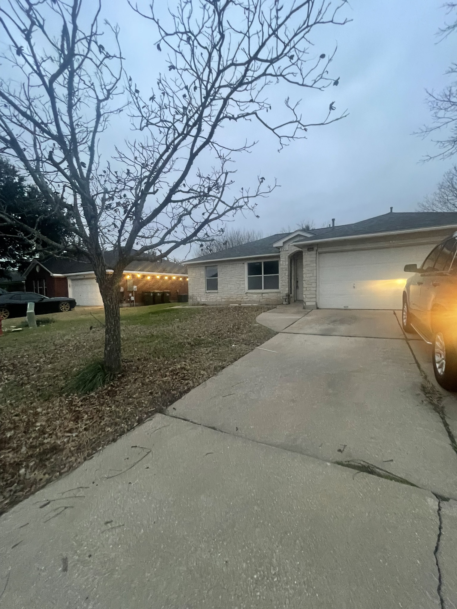 Ranch-style house with concrete driveway, a garage, and brick siding