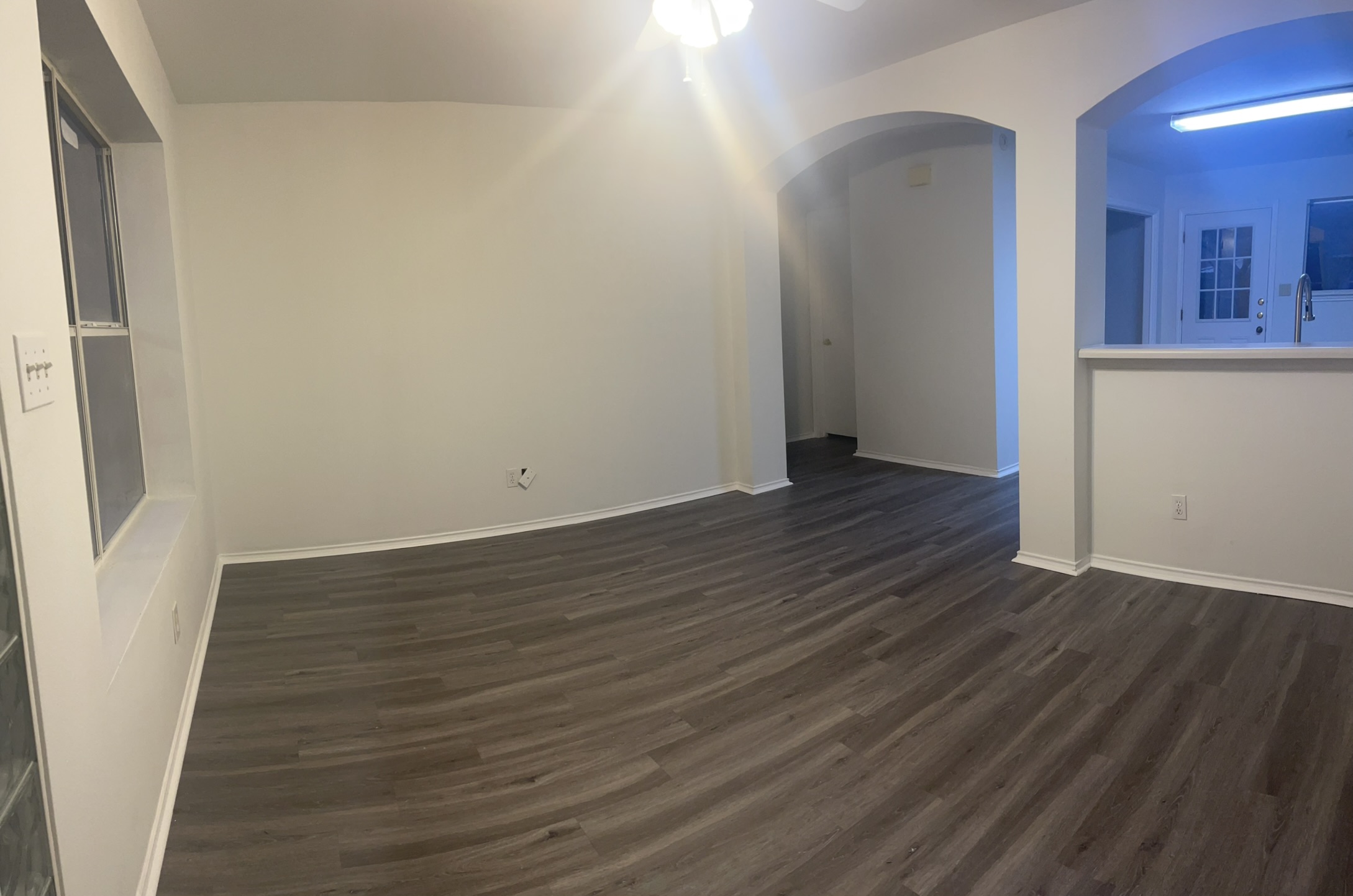 221 Britni Loop Kyle, TX 78640 - Photo 3 of 20 Unfurnished room featuring arched walkways, dark wood-type flooring, and a ceiling fan