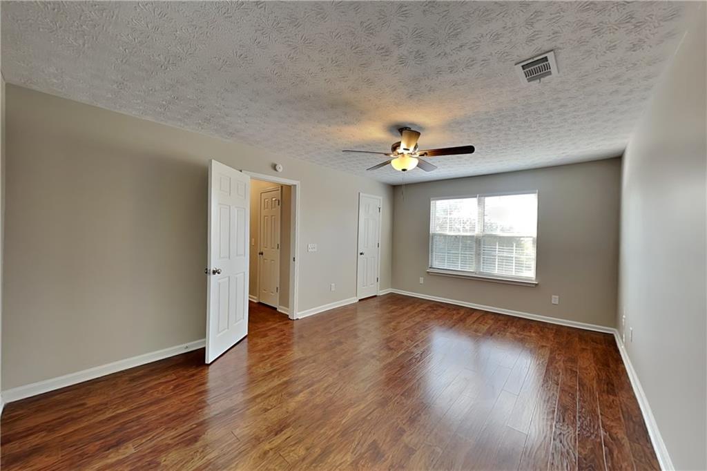 7550 Springmill Court Cumming, GA 30028 - Photo 18 of 24 a view of an empty room with wooden floor and a window