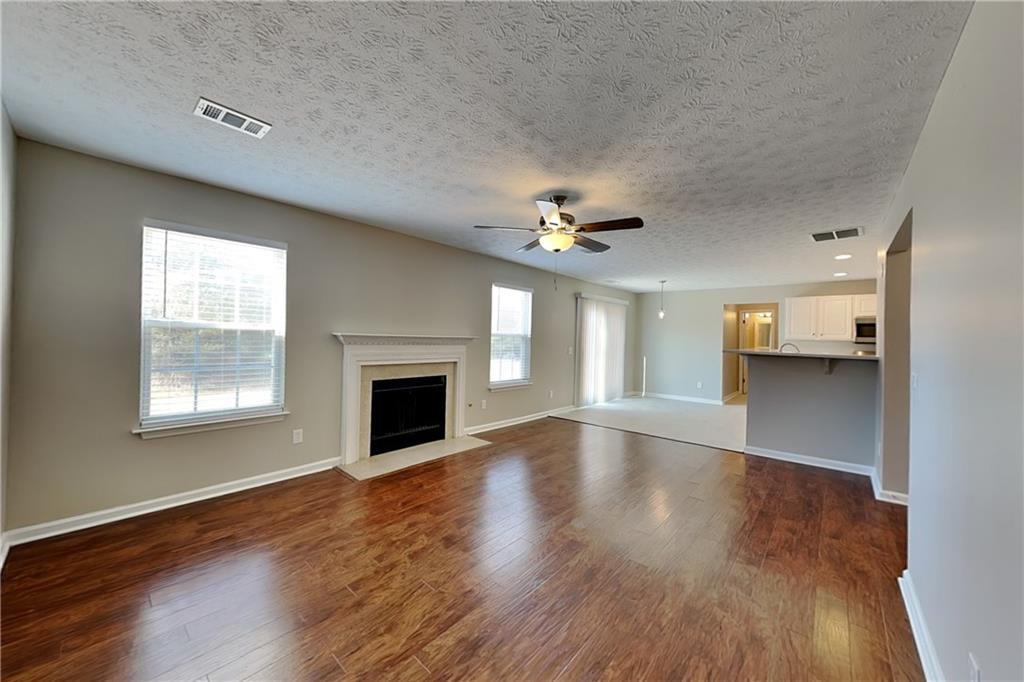 7550 Springmill Court Cumming, GA 30028 - Photo 2 of 24 a view of an empty room with a fireplace and a window