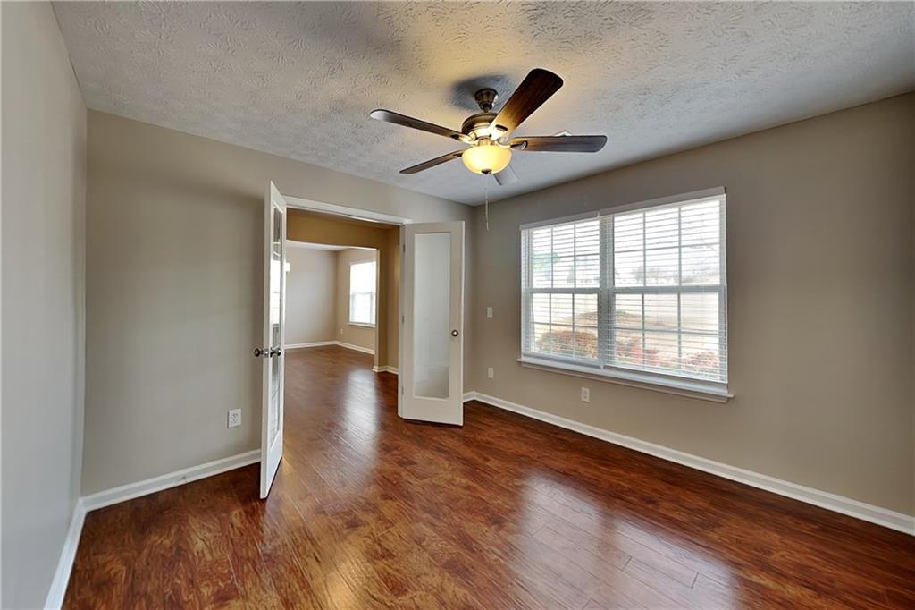 7550 Springmill Court Cumming, GA 30028 - Photo 4 of 24 a view of an empty room with window and wooden floor