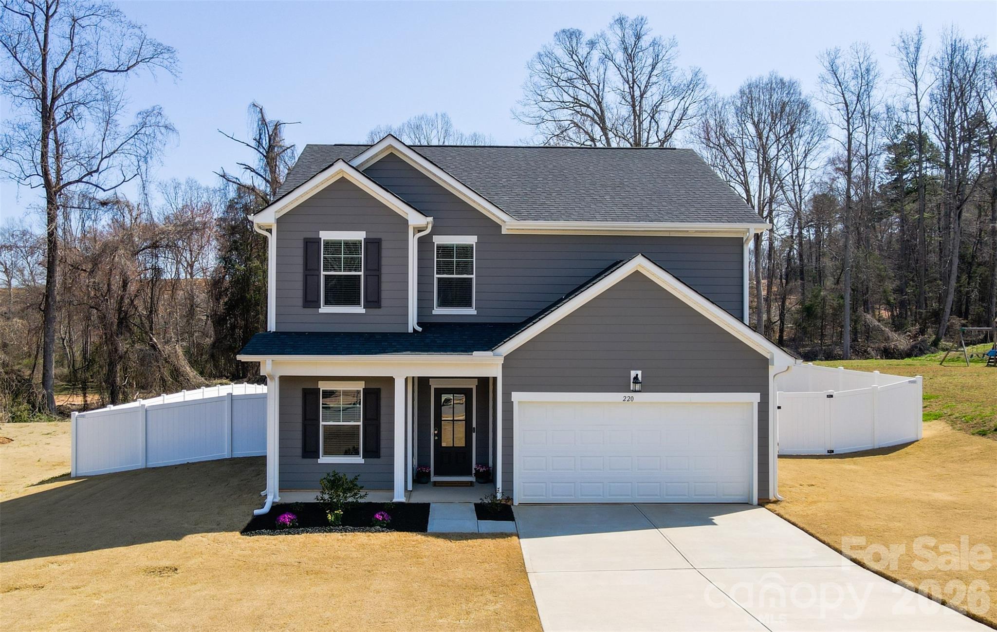 220 Sugar Hill Road Troutman, NC 28166 - Photo 2 of 37 a front view of a house with a yard and garage