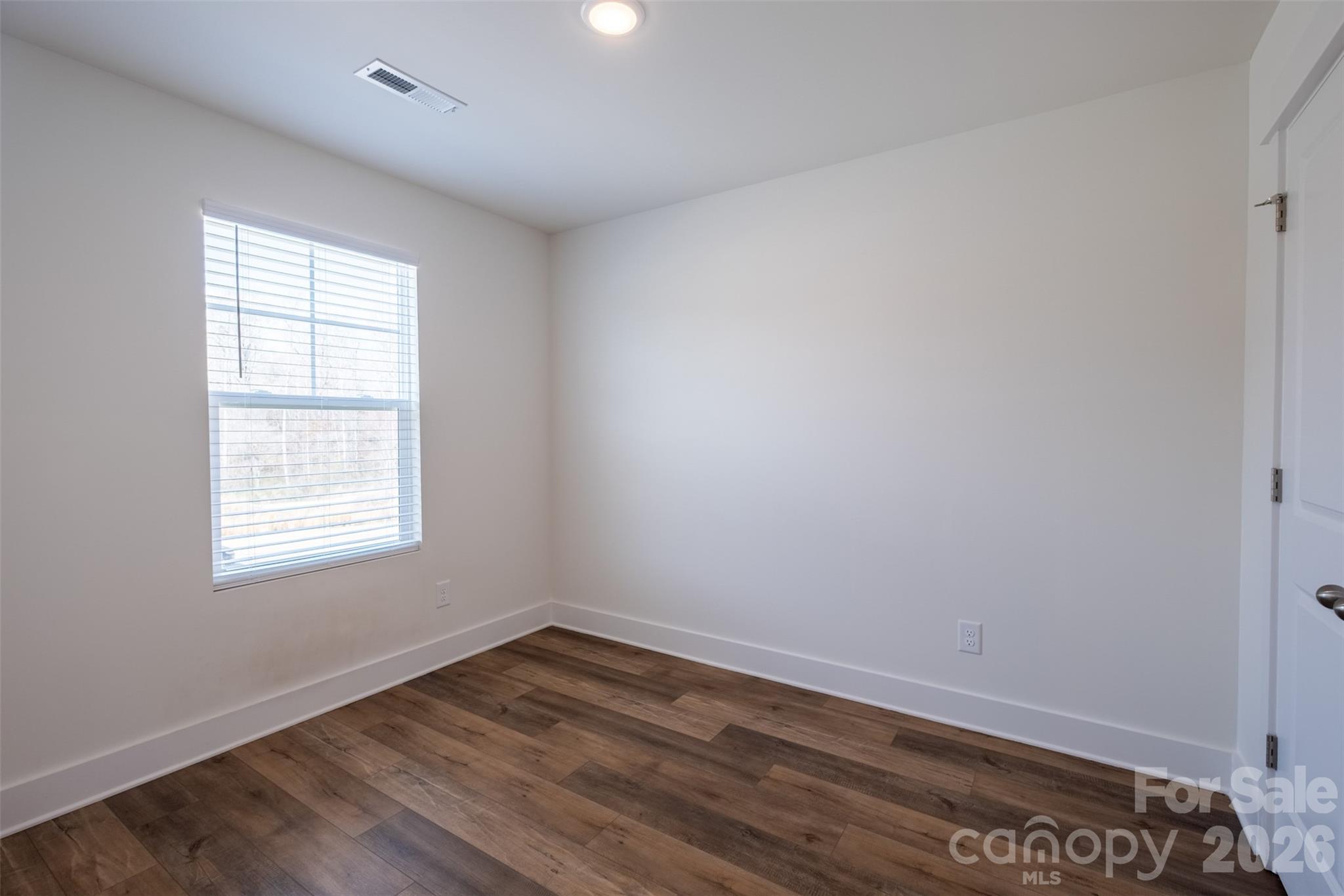 220 Sugar Hill Road Troutman, NC 28166 - Photo 21 of 37 an empty room with wooden floor and window