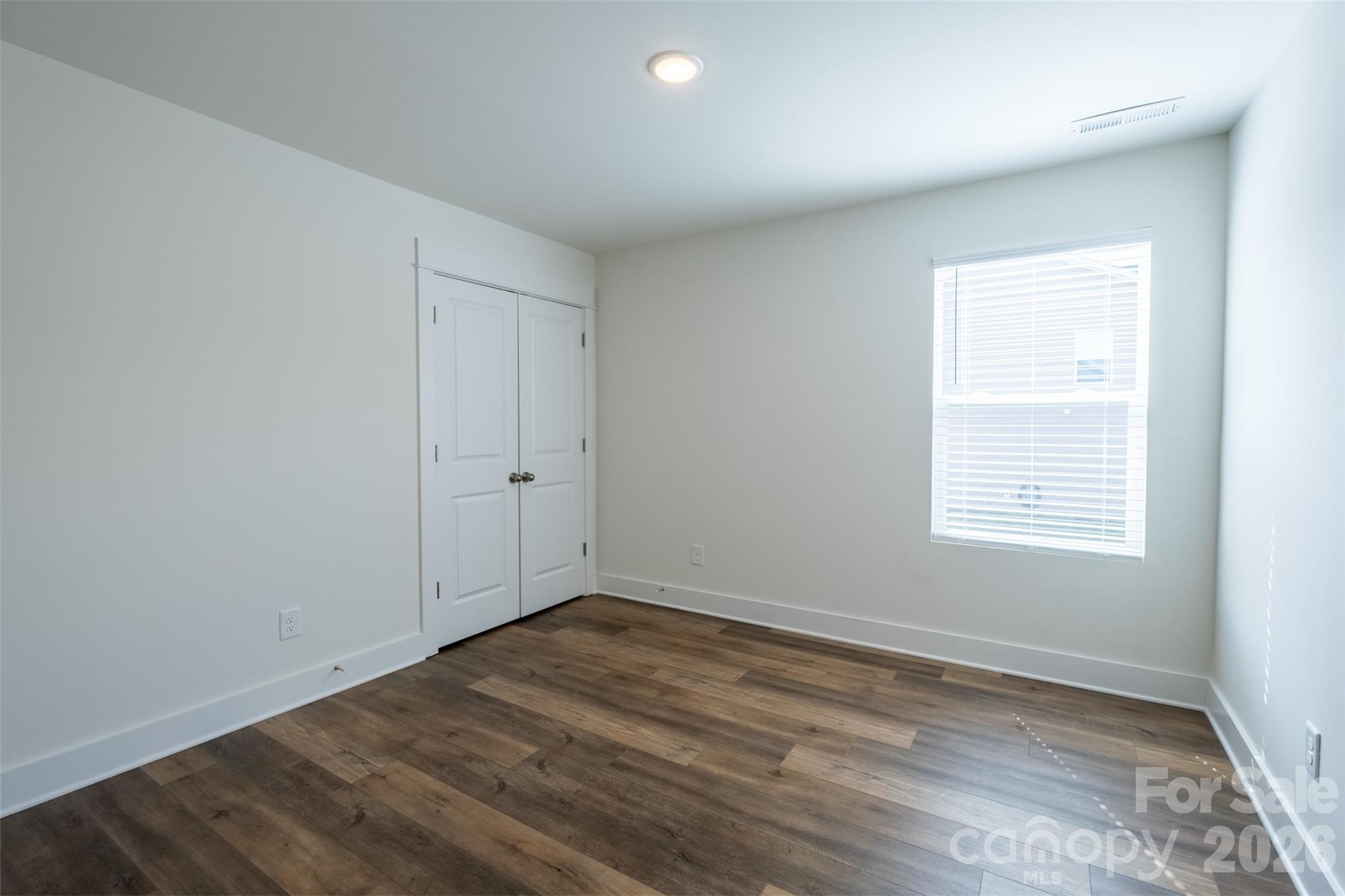 220 Sugar Hill Road Troutman, NC 28166 - Photo 25 of 37 an empty room with wooden floor and windows