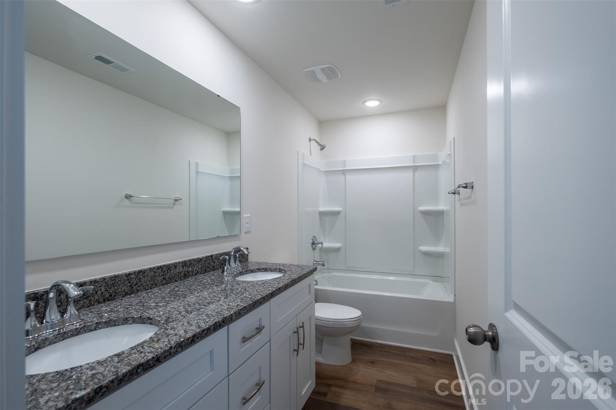 220 Sugar Hill Road Troutman, NC 28166 - Photo 27 of 37 a bathroom with a granite countertop sink a toilet and shower