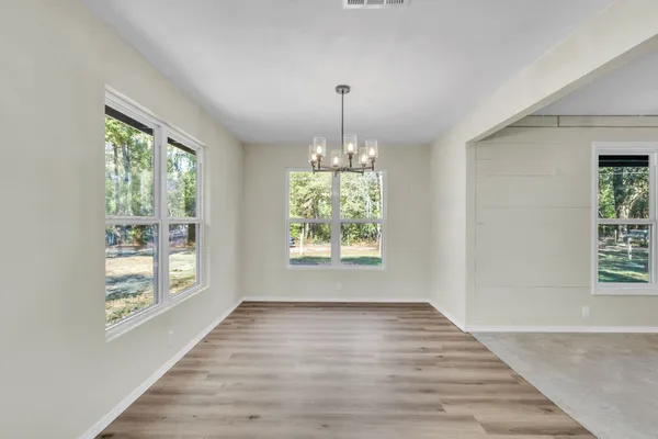 an empty room with a window and a ceiling fan