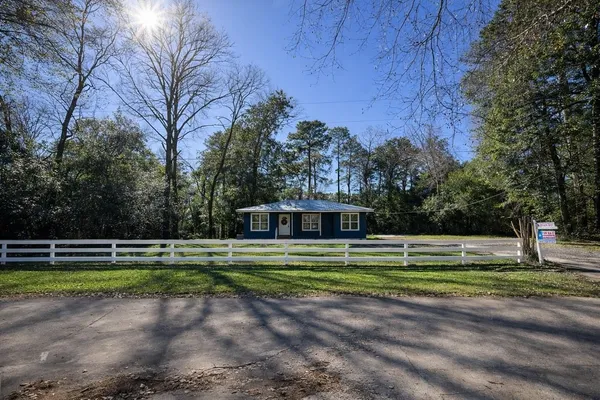a view of a tennis ground with large trees