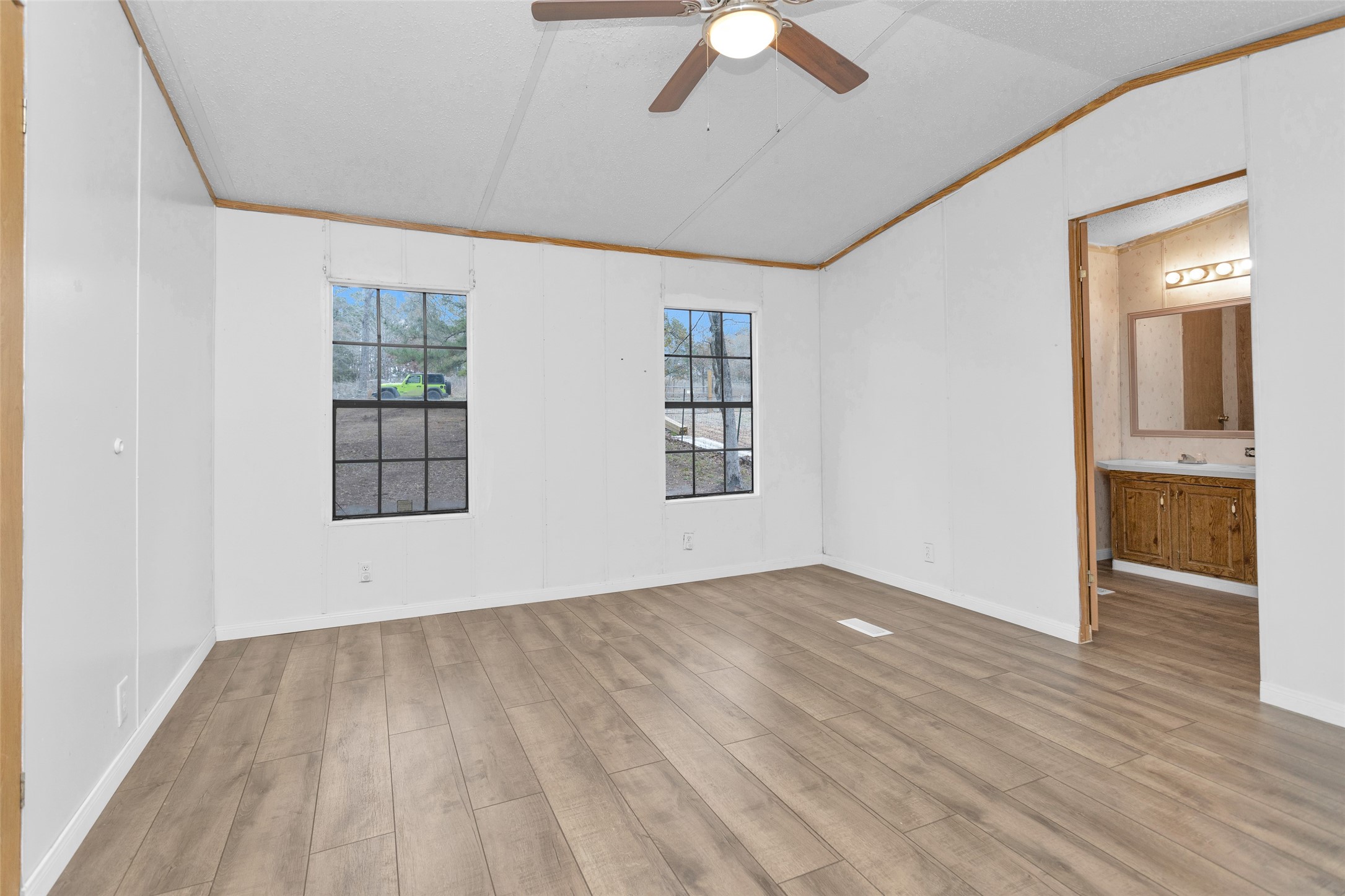 Split A Tall Pine Road Navasota, TX 77868 - Photo 19 of 22 an empty room with wooden floor chandelier fan and windows