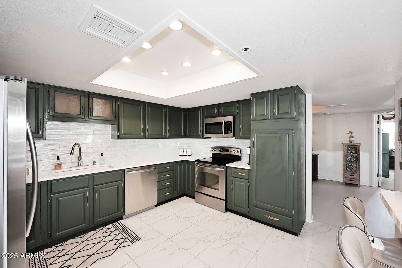 7860 East Camelback Road, Unit 404 Scottsdale, AZ 85251 - Photo 12 of 33 a kitchen with stainless steel appliances granite countertop a sink and stove top oven with wooden floor