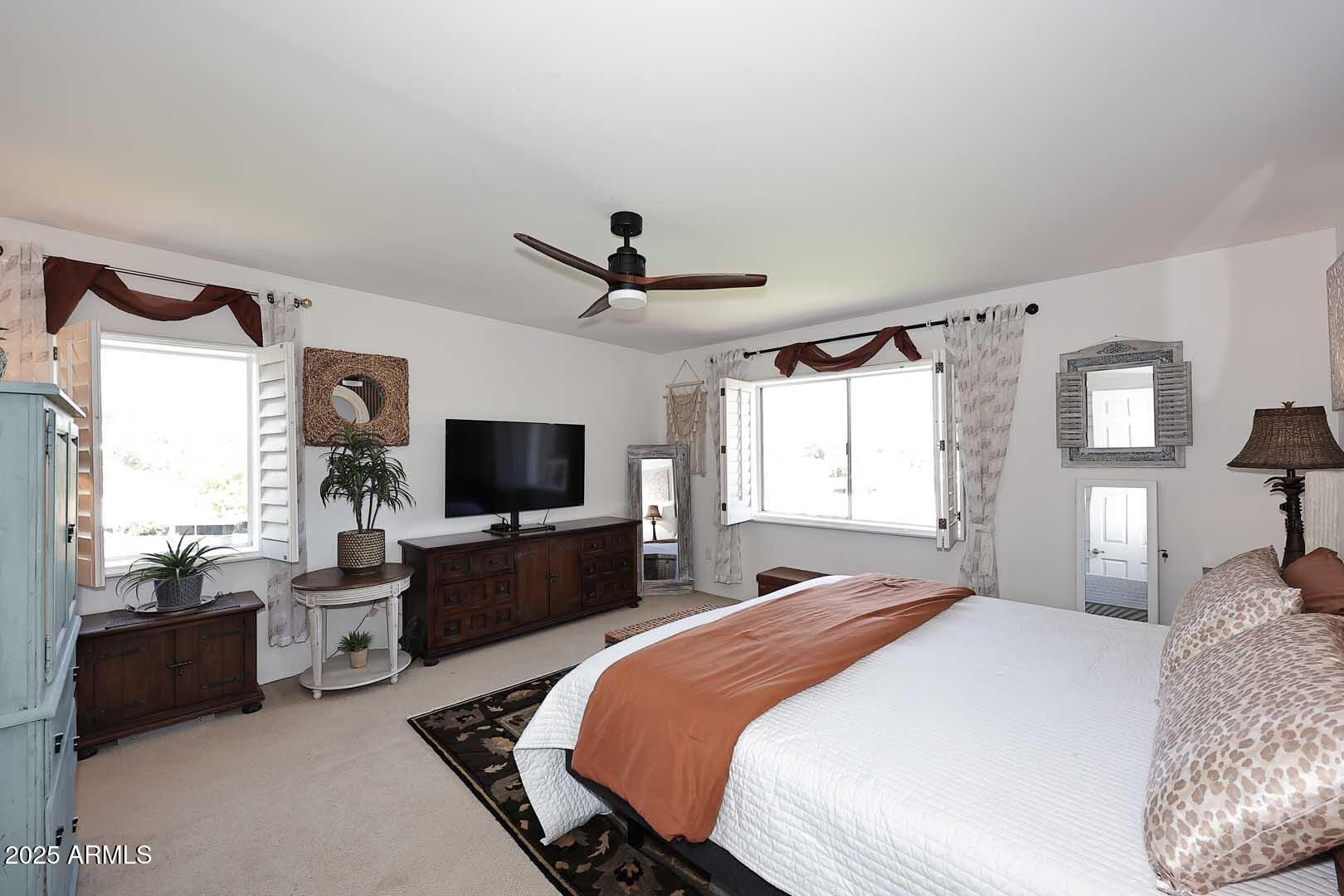 7860 East Camelback Road, Unit 404 Scottsdale, AZ 85251 - Photo 22 of 33 a spacious bedroom with a bed and a flat screen tv