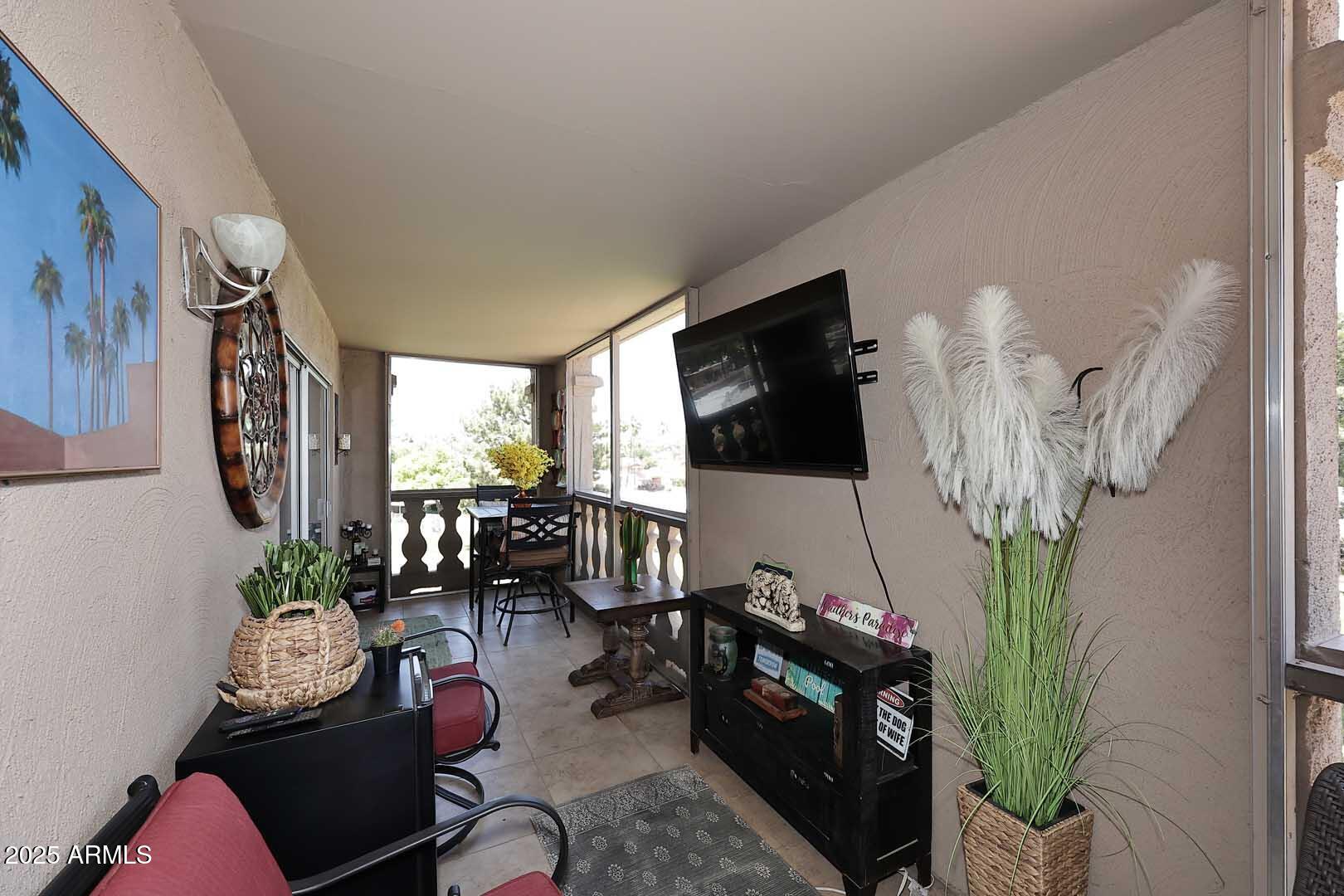 7860 East Camelback Road, Unit 404 Scottsdale, AZ 85251 - Photo 28 of 33 a living room with furniture a flat screen tv and a fireplace