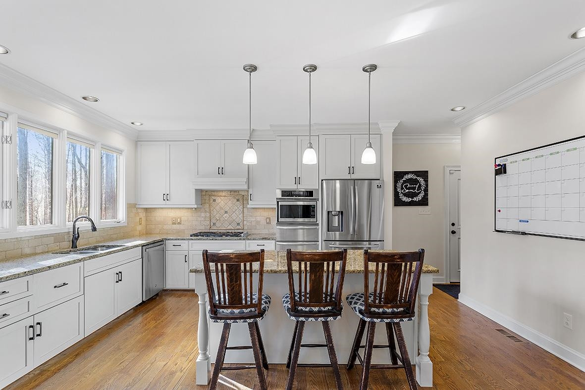 8120 Hawkshead Road Wake Forest, NC 27587 - Photo 26 of 70 a kitchen with stainless steel appliances kitchen island granite countertop a sink a stove a dining table and chairs