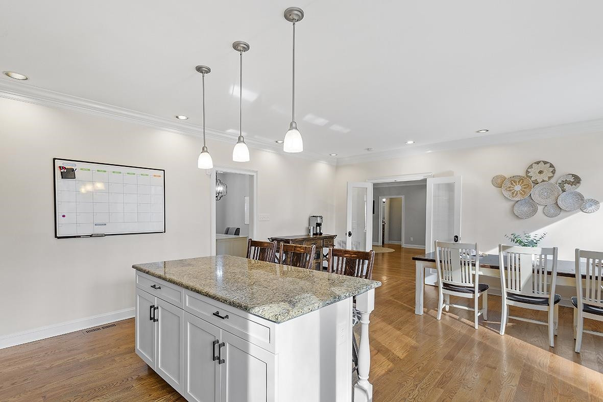 8120 Hawkshead Road Wake Forest, NC 27587 - Photo 27 of 70 a kitchen with stainless steel appliances granite countertop a kitchen island a stove and a dining table with painted walls