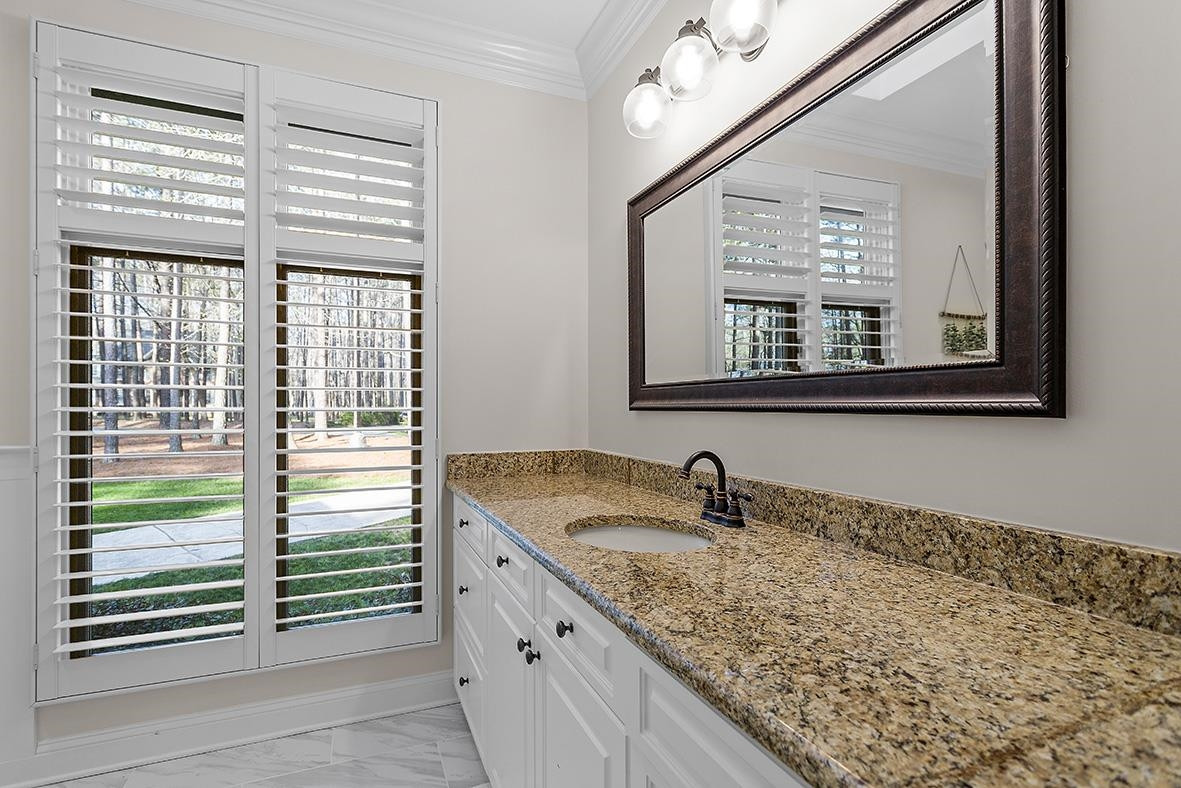 8120 Hawkshead Road Wake Forest, NC 27587 - Photo 34 of 70 a bathroom with a granite countertop sink and a window