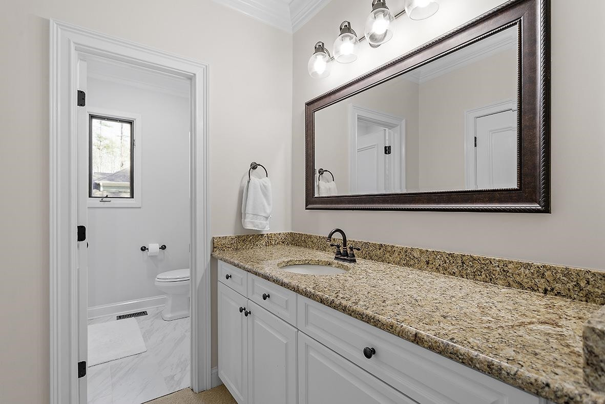 8120 Hawkshead Road Wake Forest, NC 27587 - Photo 35 of 70 a bathroom with a granite countertop sink and a mirror