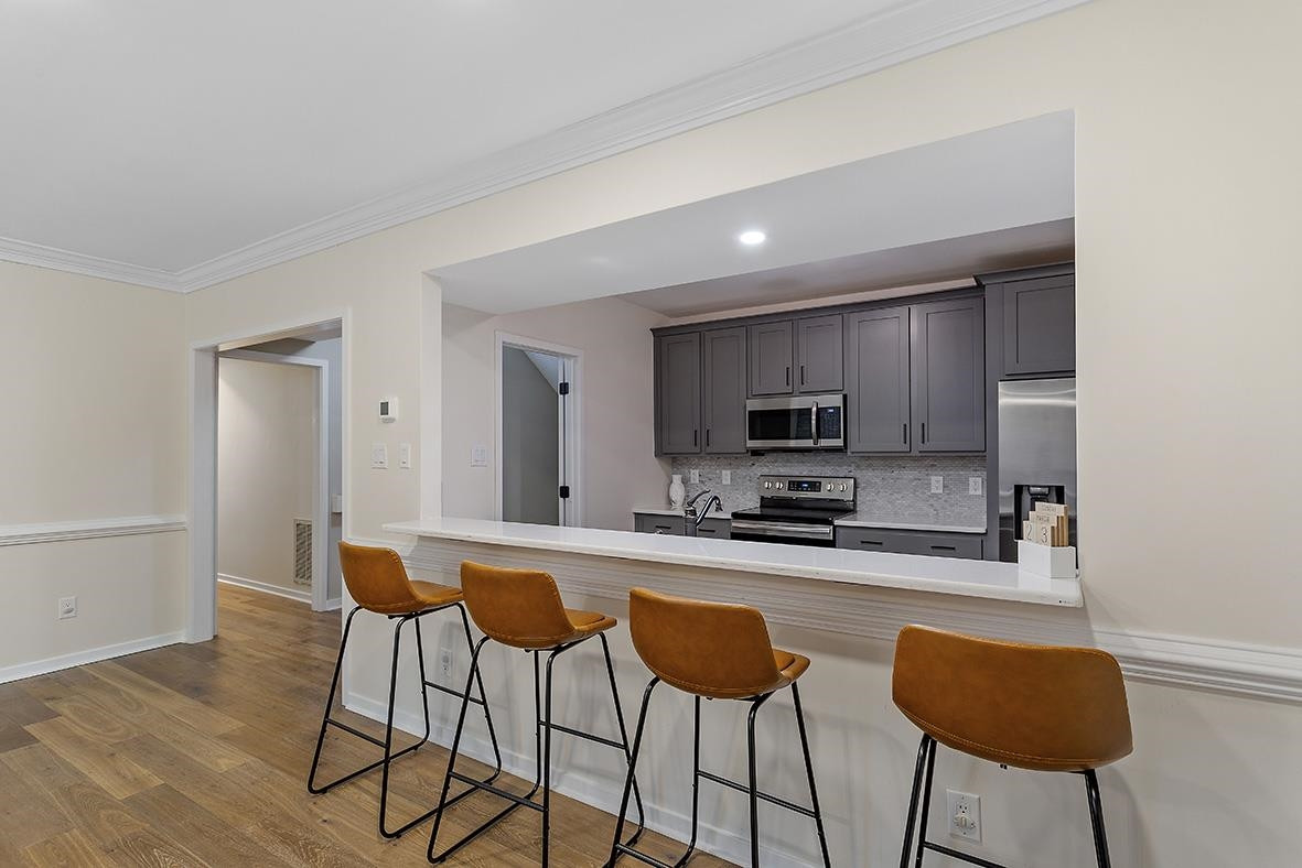 8120 Hawkshead Road Wake Forest, NC 27587 - Photo 42 of 70 a kitchen with stainless steel appliances kitchen island granite countertop a sink and chairs