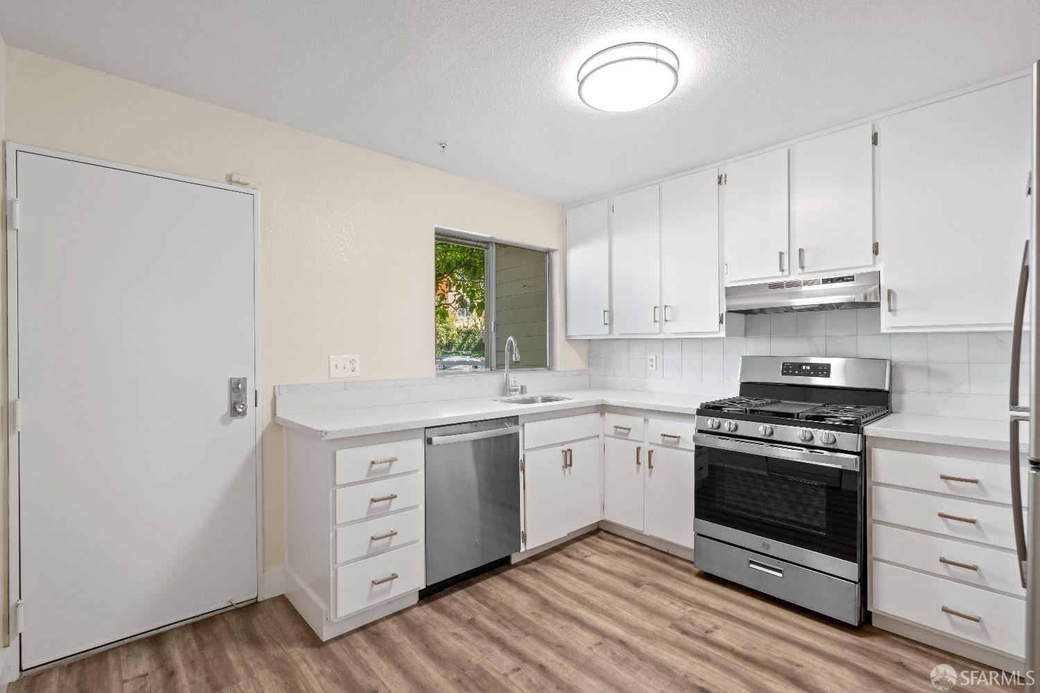 1862 Ellis Street, Unit B San Francisco, CA 94115 - Photo 12 of 41 a kitchen with cabinets appliances and a wooden floor
