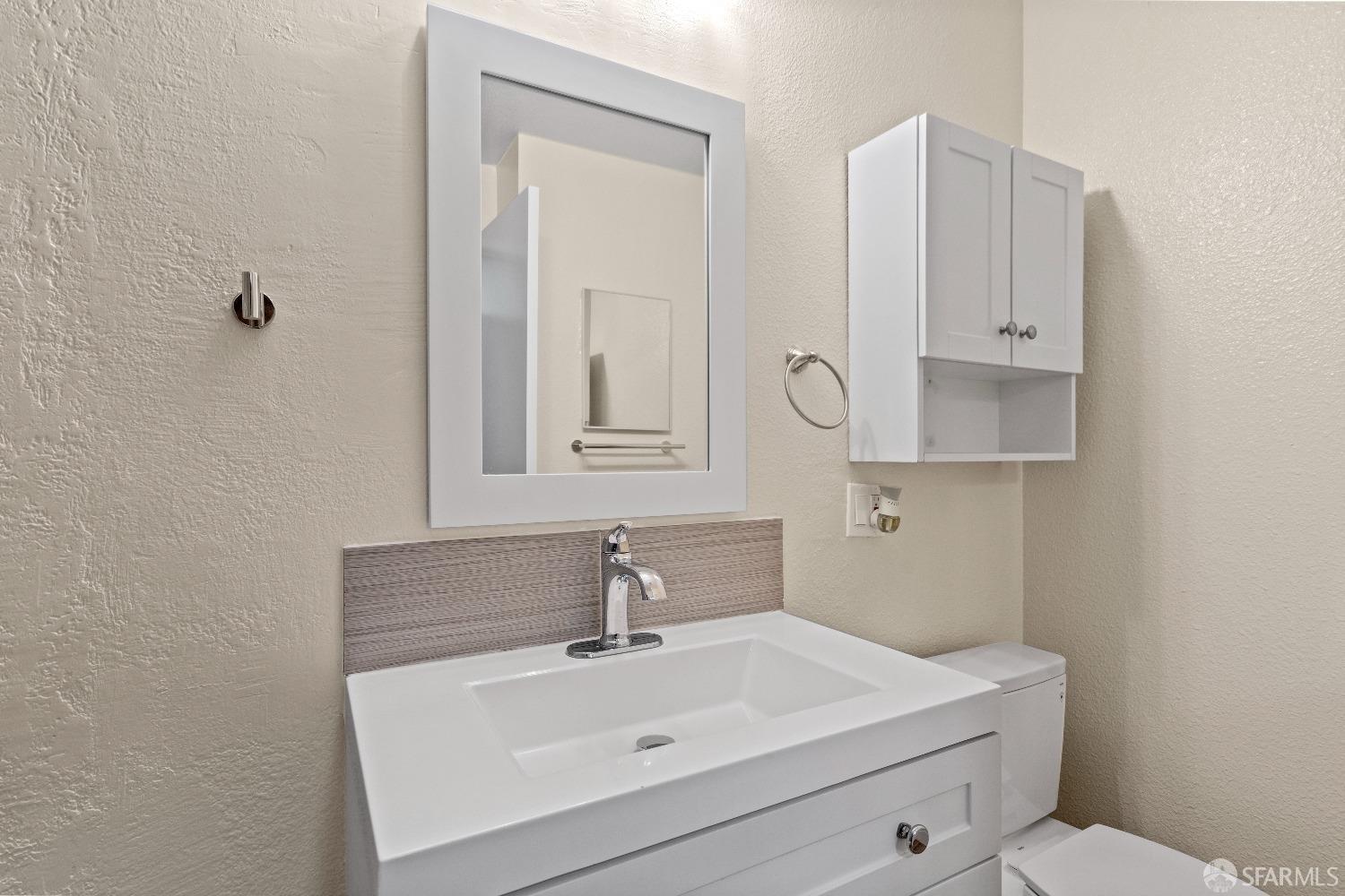 1862 Ellis Street, Unit B San Francisco, CA 94115 - Photo 25 of 41 a bathroom with a sink a toilet and mirror