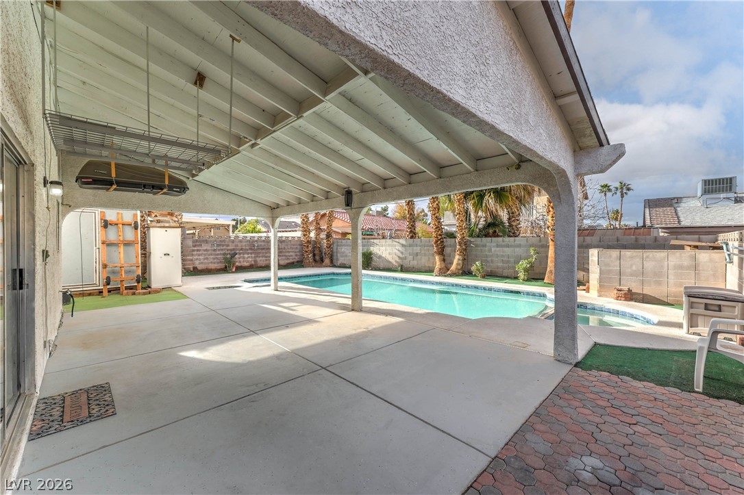 581 Carleton Drive Henderson, NV 89014 - Photo 25 of 37 A spacious covered patio overlooks a private, shimmering pool, perfect for outdoor relaxation.