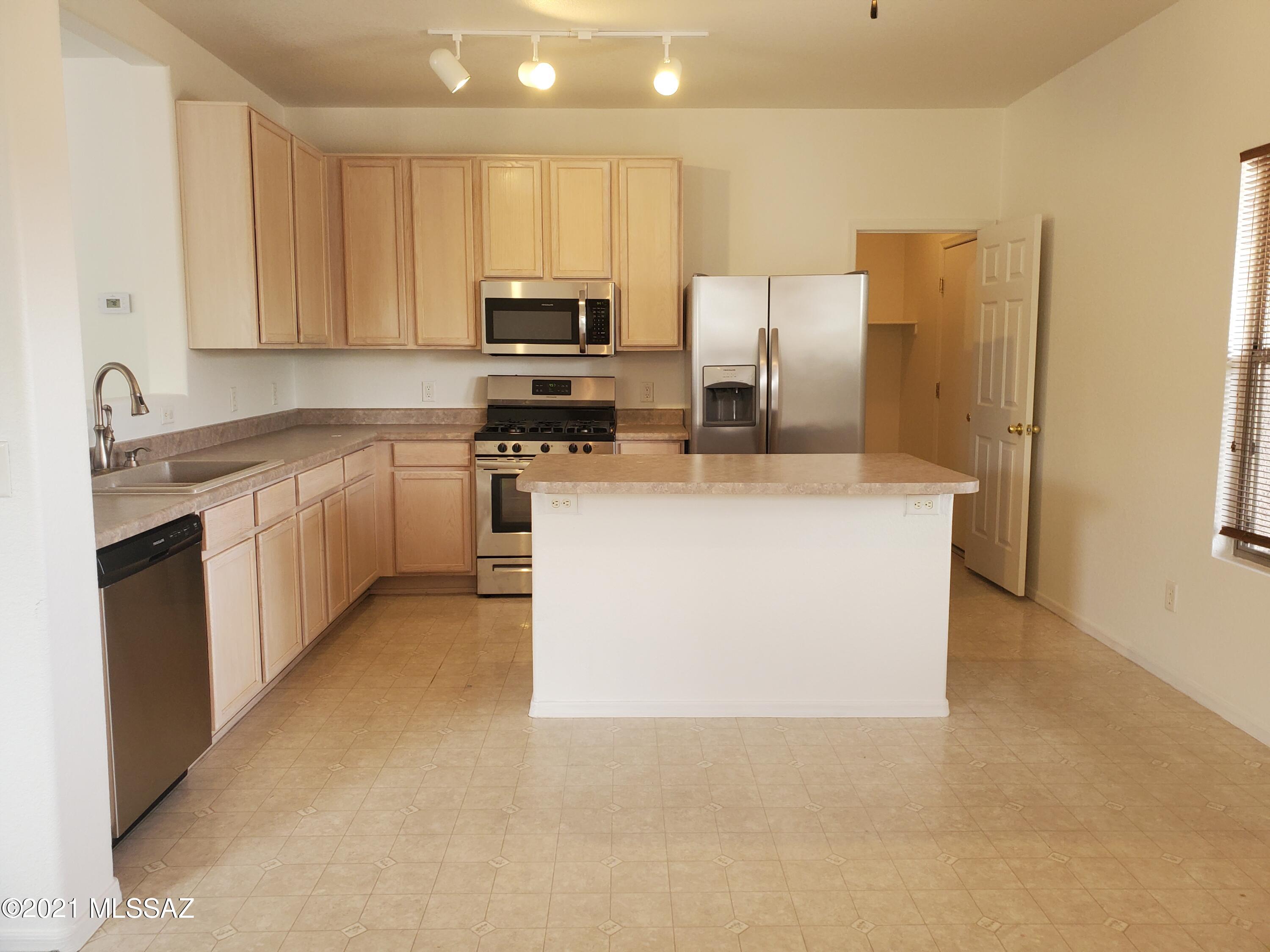 3455 North Boyce Spring Lane Tucson, AZ 85745 - Photo 3 of 21 a kitchen with stainless steel appliances a refrigerator stove microwave and sink
