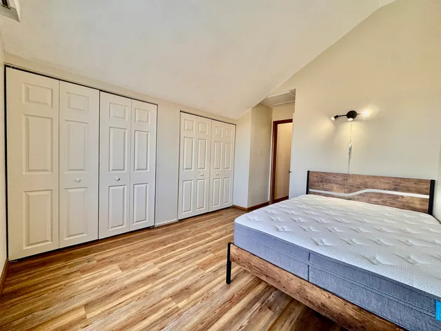 a bedroom with a bed and wooden floor