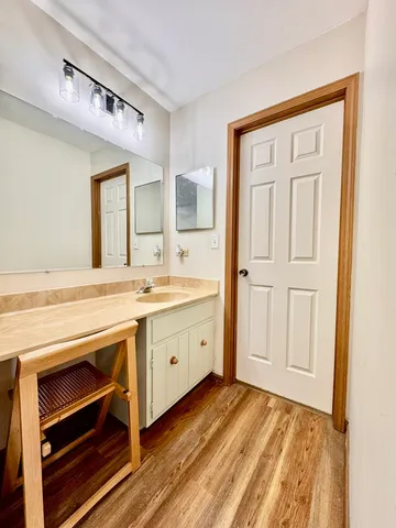 a spacious bathroom with a granite countertop sink and a mirror