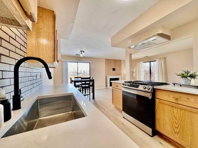 a kitchen with stainless steel appliances granite countertop a stove a sink and a microwave