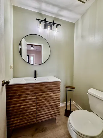 a bathroom with a sink a mirror a toilet and a mirror