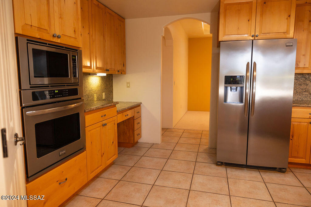 771 West Sedona Ridge Place Oro Valley, AZ 85755 - Photo 11 of 22 a kitchen with granite countertop a refrigerator and a stove