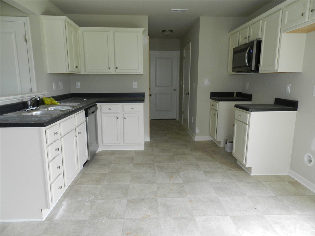 87 Willow Ridge Circle Willow Spring, NC 27592 - Photo 3 of 7 a kitchen with granite countertop white cabinets and stainless steel appliances
