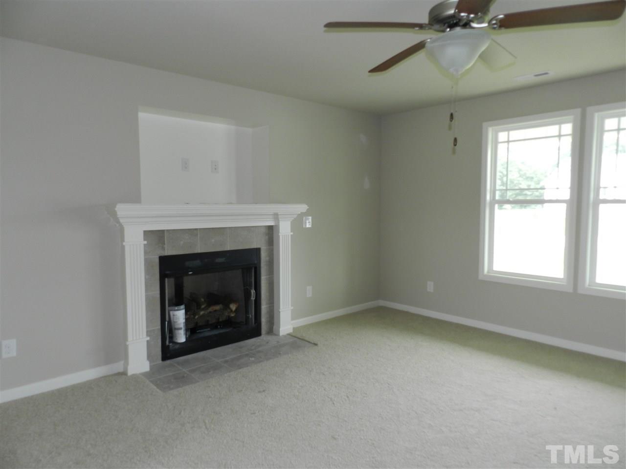 87 Willow Ridge Circle Willow Spring, NC 27592 - Photo 4 of 7 an empty room with a fireplace and windows