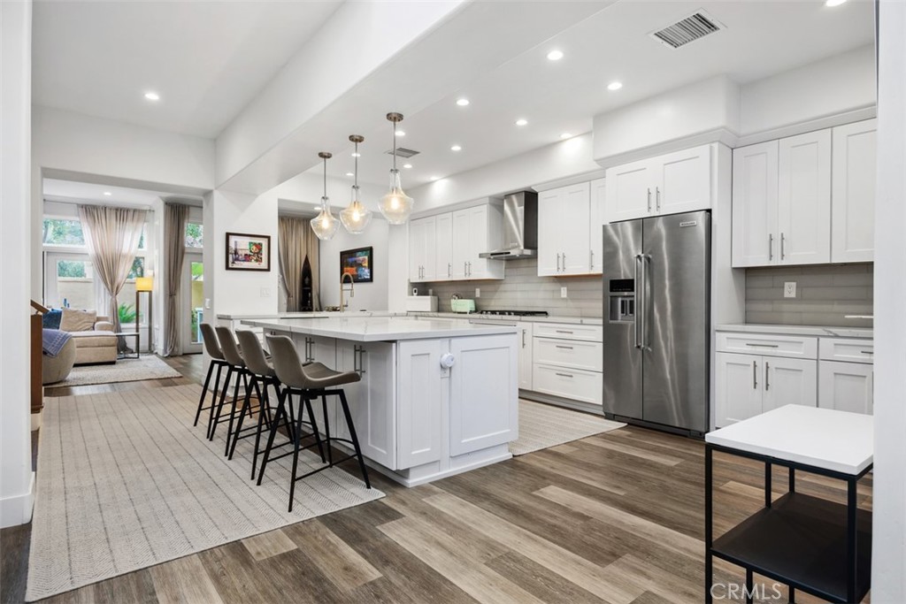 a kitchen with stainless steel appliances a dining table chairs microwave and sink