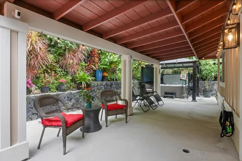 a view of a patio with table and chairs potted plants with floor to ceiling window