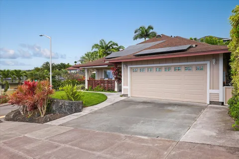 a front view of a house with a yard and potted plants