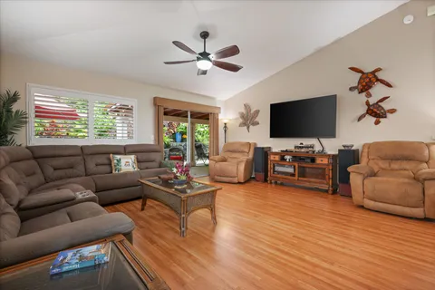 a living room with furniture kitchen view and a large window