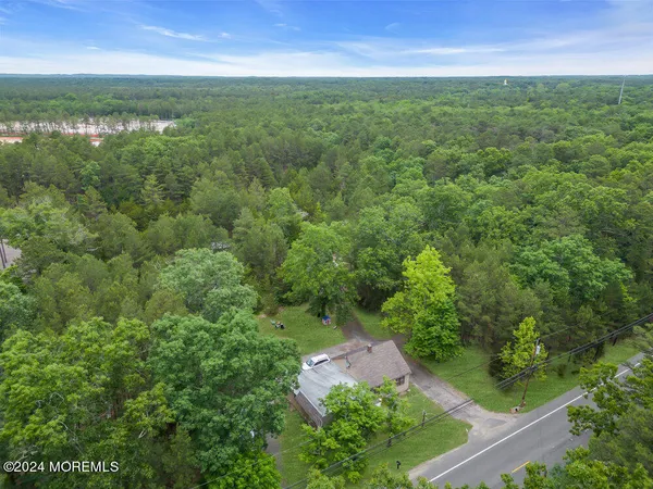 an aerial view of residential houses with outdoor space and trees
