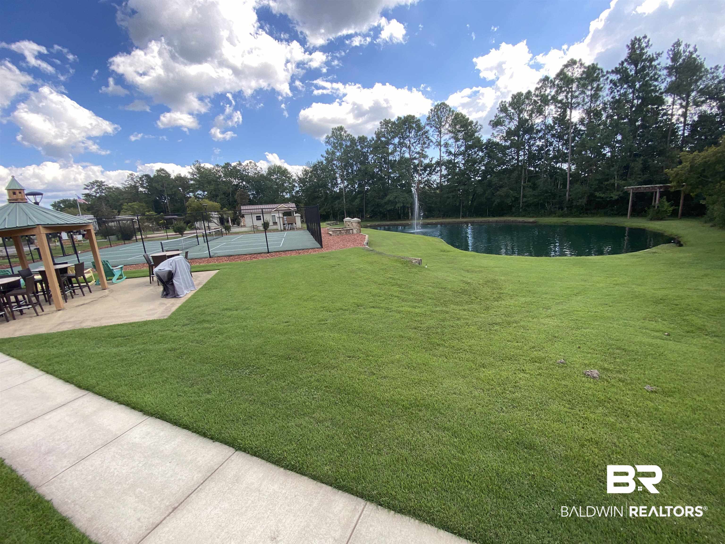 28238 Migratory Way Elberta, AL 36530 - Photo 52 of 58 View of yard with a patio, a gazebo, a water view, a tennis court, and view of scattered trees