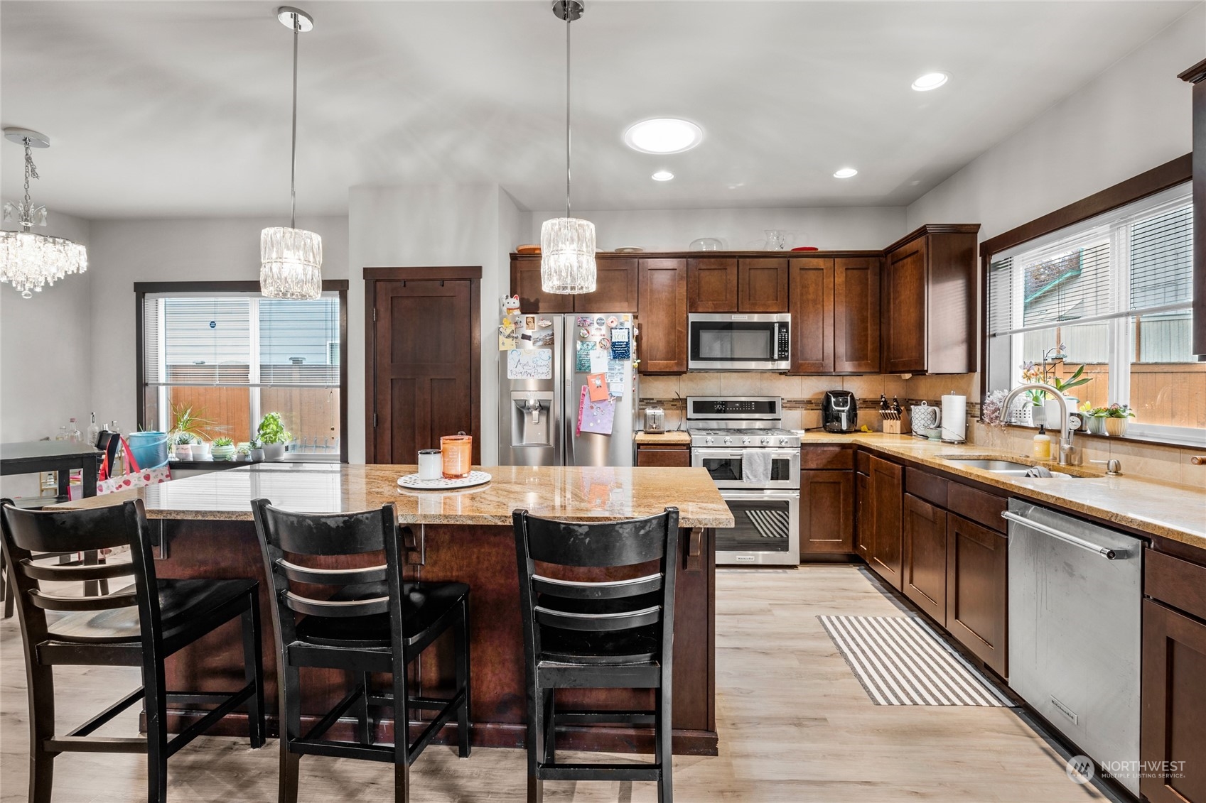 7521 Broadway Everett, WA 98203 - Photo 11 of 25 a kitchen with stainless steel appliances kitchen island granite countertop a table chairs and a refrigerator