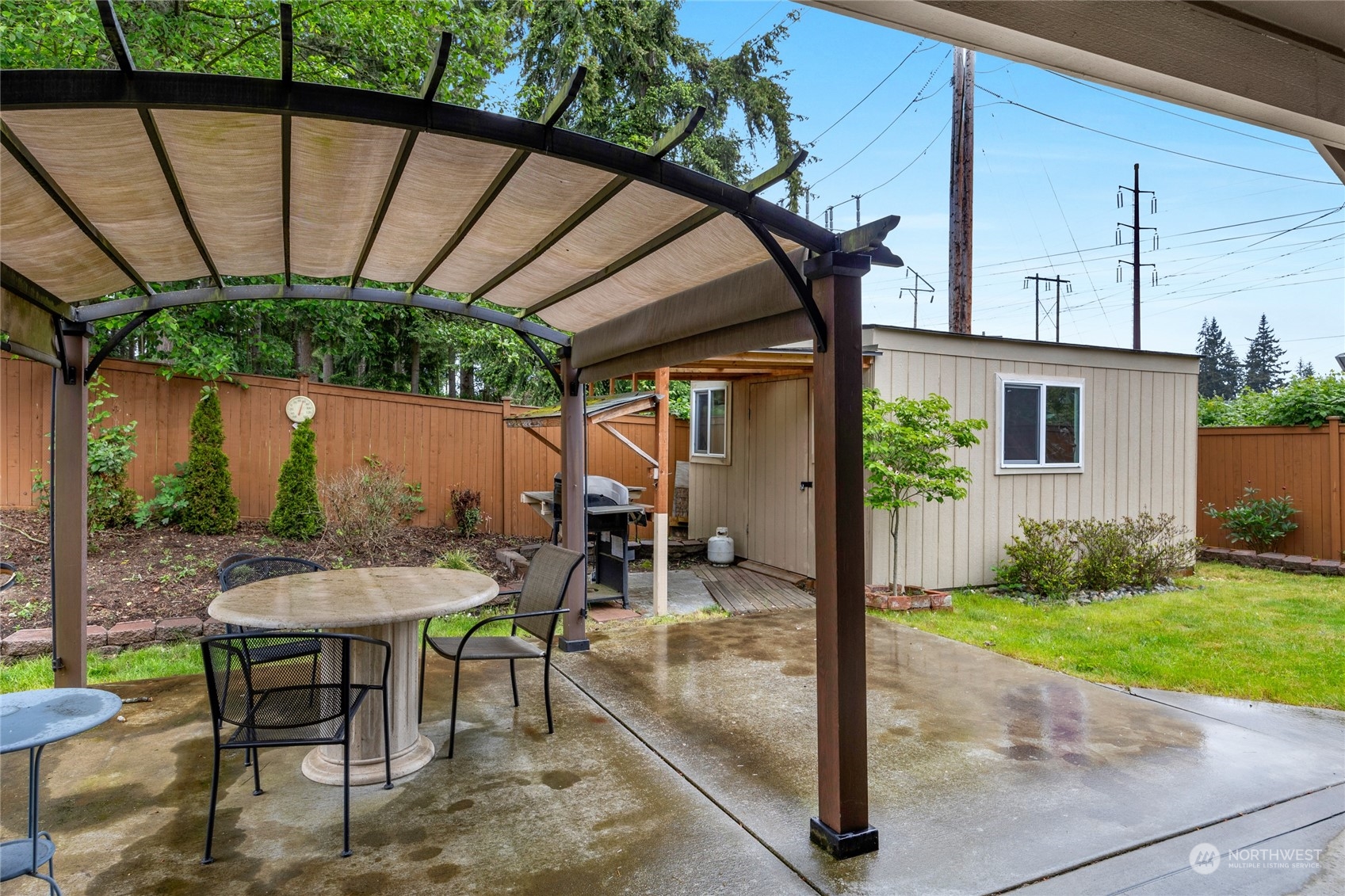 7521 Broadway Everett, WA 98203 - Photo 22 of 25 a view of a patio with table and chairs under an umbrella with a small yard