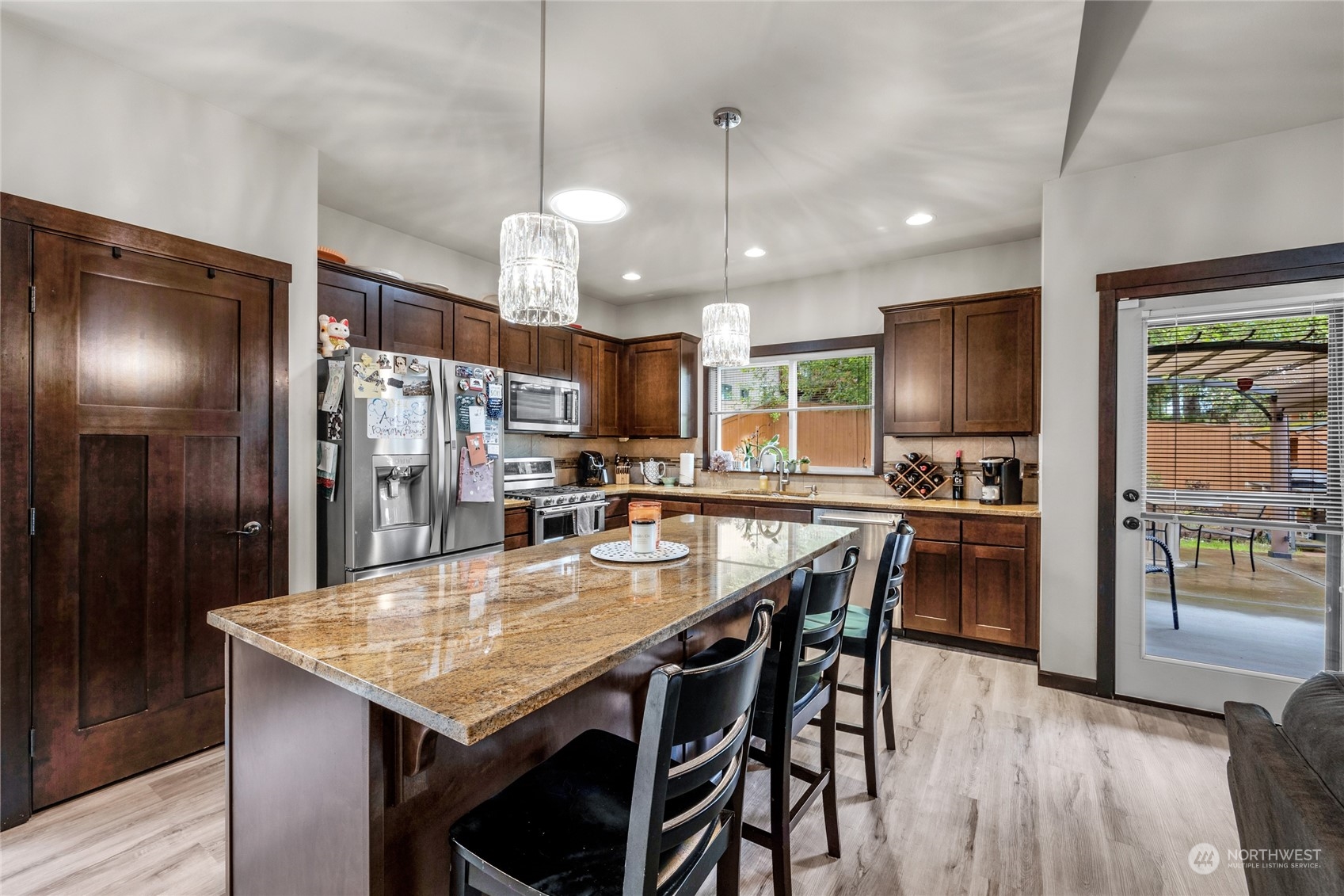 7521 Broadway Everett, WA 98203 - Photo 9 of 25 a kitchen with stainless steel appliances kitchen island granite countertop a refrigerator a stove a kitchen island a dining table and chairs