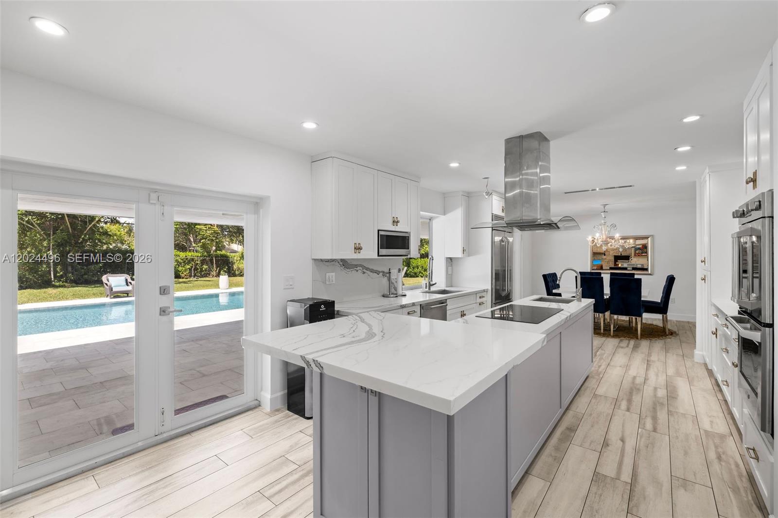 6875 North Cartee Road Palmetto Bay, FL 33158 - Photo 16 of 42 a kitchen with a sink a counter top space stainless steel appliances and windows