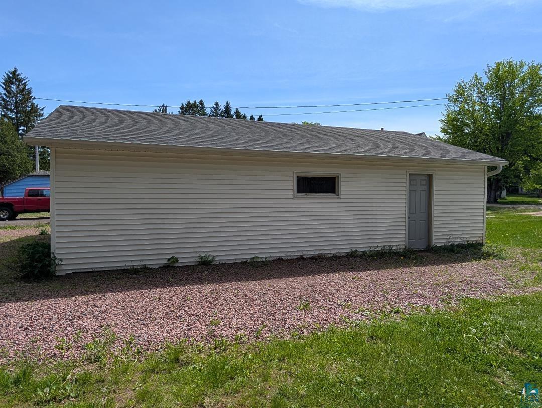 202 Thomas Street Mellen, WI 54546 - Photo 5 of 6 Detached garage with horizontal vinyl siding, a gray asphalt shingle roof, and a side entry door