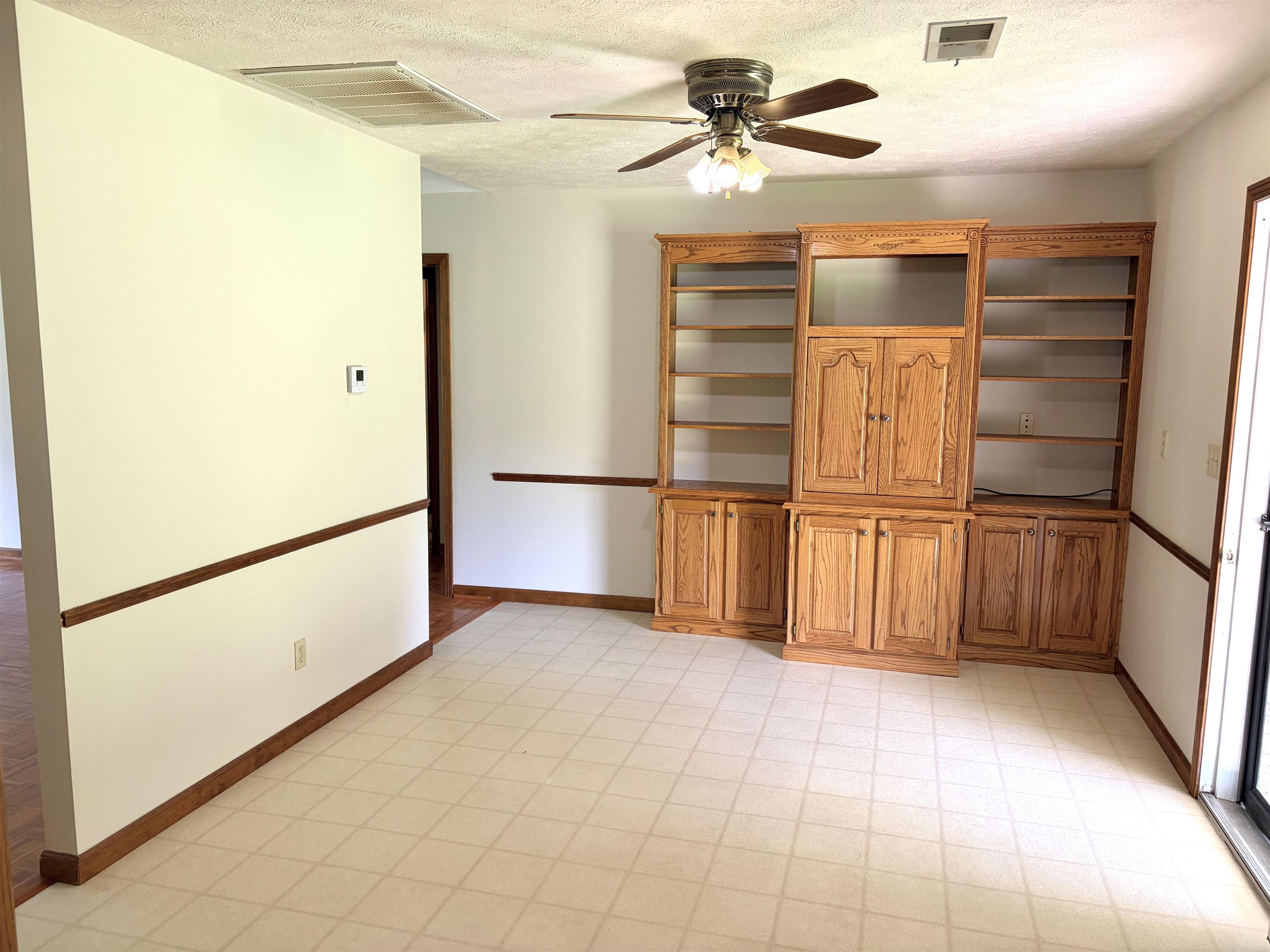 640 Red Bird Road Middleton, TN 38052 - Photo 9 of 30 Built-in wood cabinetry with open shelving and closed storage, ceiling fan with light fixture, light-toned square tile flooring, wood trim detailing on walls, and painted white walls