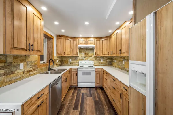 a kitchen with kitchen island granite countertop counter top space a sink stainless steel appliances and cabinets