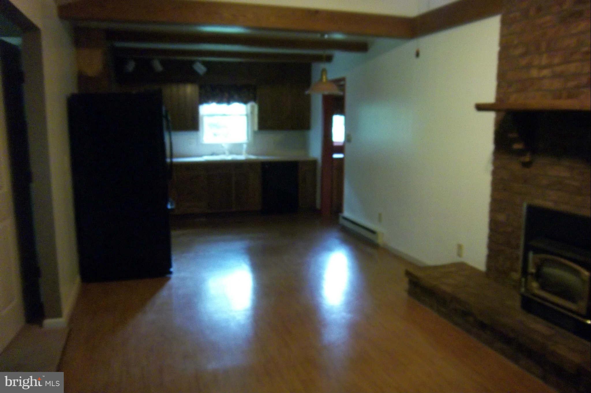 7749 Talhelm Road Chambersburg, PA 17202 - Photo 5 of 26 a view of a livingroom with wooden floor and a fireplace